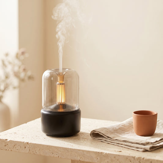 Candlelight aroma diffuser in beige — glass bell jar body with warm candlelight LED