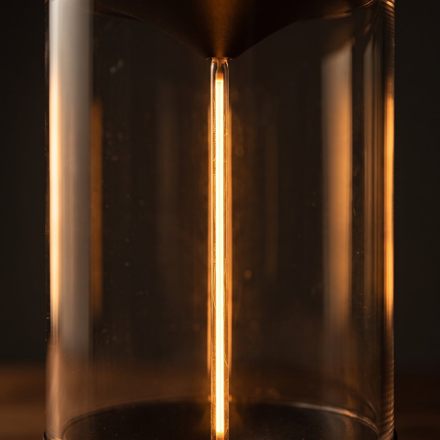 Close-up inside the crystal acrylic flex filament lantern — warm LED filament coil