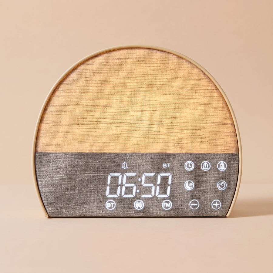 Fabric Sunrise Clock with its linen face lit warm gold, showing 06:50